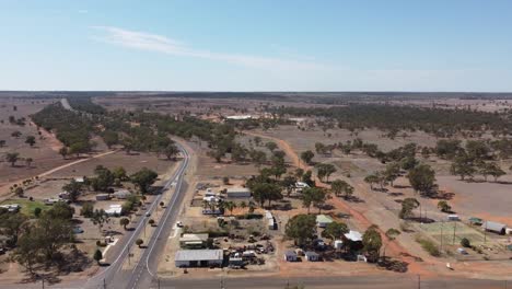 Aerial-view-of-a-small-town-and-a-highway-passing-through-with-intersection