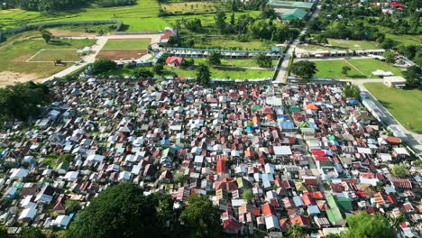 Aerial-view-of-a-local-cemetery-revealing-city-and-sea-lane,-Philippines