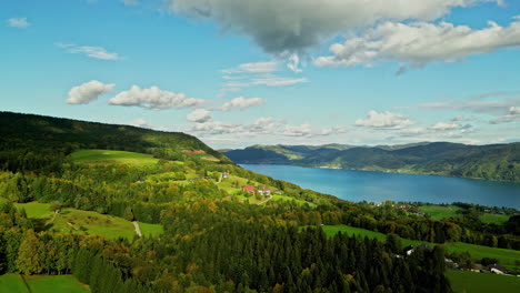 Aerial-tracking-shot-of-fall-foliage-colors-at-lake-Attersee,-in-sunny-Austria