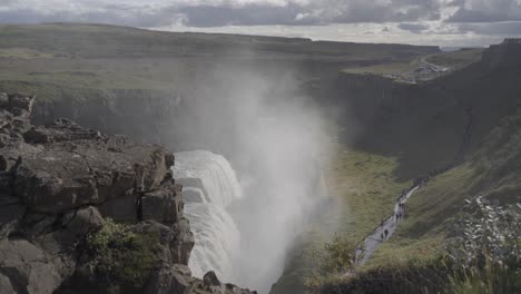 Static-shot-of-the-Gullfoss-waterfall-with-tourists-walking-past-in-Iceland