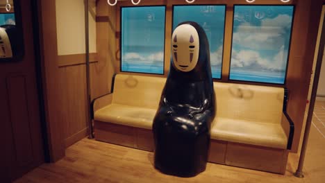Japanese-Kaonashi-"No-Face"-Monster-from-Spirited-Away-Sitting-on-Train