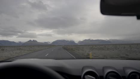 Toma-En-Cámara-Lenta-De-Un-Automóvil-Conduciendo-Por-Una-Carretera-En-La-Islandia-Rural
