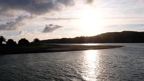 Scenic-landscape-view-of-Raglan-estuary-during-sunset-with-evening-sunlight-reflecting-over-ocean-water-in-New-Zealand-Aotearoa