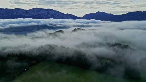 Sunrise-over-misty-landscape-with-the-view-of-mountains-in-the-background,-Above-the-clouds-and-trees-in-misty-landscape-with-mountains-in-backdrop,-Remote-jungle-scenery,-Austria