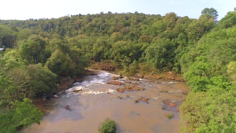 Drohne-Nähert-Sich-Einem-Fluss-Mit-Vielen-Felsen-Und-Strömung-Mitten-Im-Dschungel