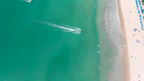 A-distant-orbit-aerial-drone-shot-of-the-sandy-white-Kata-Beach-located-in-Phuket-island,-in-the-south-of-Thailand