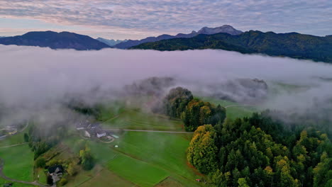 Aerial-view-of-foggy-farmlands-and-rural-nature-of-Saltzkammergut,-autumn-in-Austria