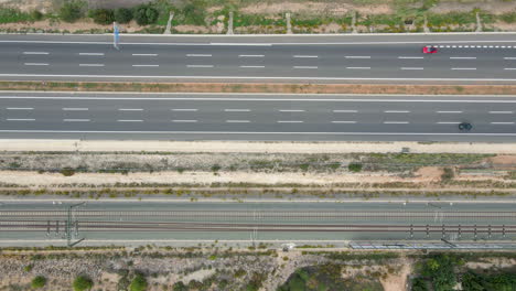Luftaufnahme-Der-Autobahn-Valencia-Madrid-Mit-Autos,-Die-In-Entgegengesetzte-Richtungen-Neben-Den-Bahngleisen-Der-Ave-Renfe-Fahren