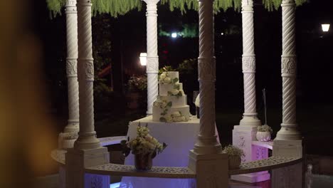 Nighttime-wedding-setting-with-ornate-pillars-and-elegant-cake
