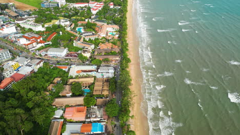 Aerial-flying-over-coastline-and-main-street-of-Ao-Nang-on-sunny-day,-Thailand