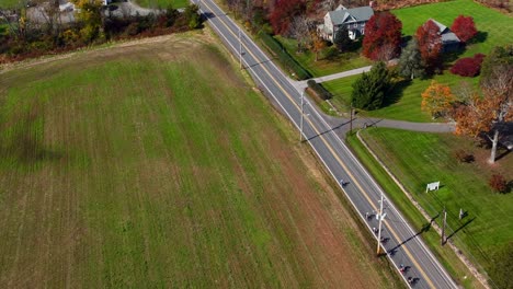 An-aerial-view-of-a-two-lane-road-in-a-rural-area-of-New-Jersey-with-farmland-and-large-green-fields-on-a-sunny-day
