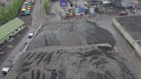 Aerial-view-of-stock-of-aggregates-in-the-form-of-sand,-gravel-and-filler-at-an-asphalt-plant-near-the-Asphalt-Mixing-Plant-machine-building-and-other-heavy-construction-equipment