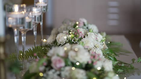 Elegante-Tischdekoration-Bei-Kerzenschein-Mit-Frischen-Weißen-Blumen