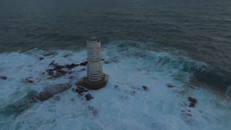 Mangiabarche-Lighthouse,-Sardinia:-Fantastic-aerial-view-orbiting-the-beautiful-lighthouse-and-with-the-waves-hitting-the-rocks