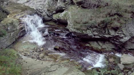A-rocky-stream-bed-over-which-the-water-flows-downhill-in-the-Antrona-Valley-Natural-Park-in-the-Verbano-Cusio-Ossola-province-in-Piedmont,-Italy