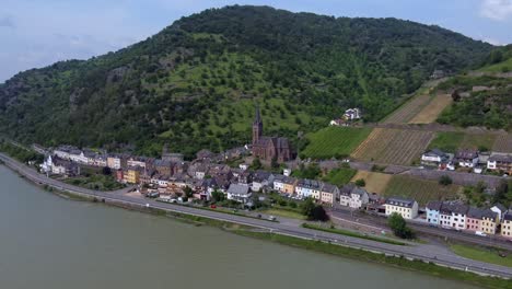 Mittelalterliche-Kirche-Und-Bunte-Häuser-Am-Flussufer-Der-Deutschen-Stadt-Lorchhausen
