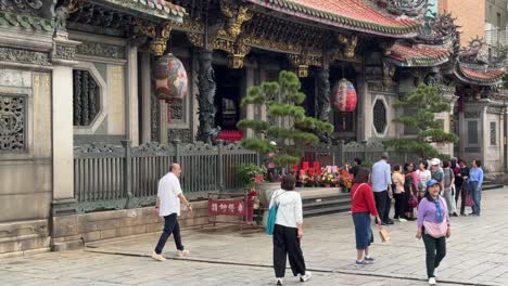 Tilt-down-shots-of-the-architectural-details-and-people-offering-prayers-of-the-famous-heritage-Bangka-Longshan-Temple-in-Wanhua-District,-Taipei,-Taiwan