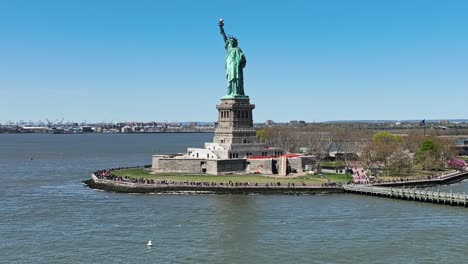 Aerial-drone-shot-showing-many-tourist-visiting-Statue-of-Liberty-during-Beautiful-summer-day-in-NYC