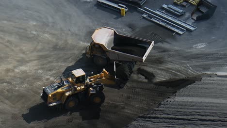 Rising-drone-telephoto-shot-of-a-front-end-loader-loading-a-rock-truck-with-limestone-aggregates-in-a-quarry-near-Ottawa-Ontario-Canada