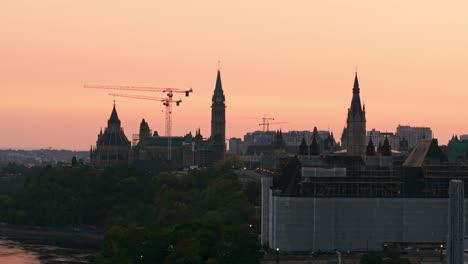 Gebäude-Des-Obersten-Gerichtshofs-Und-Des-Parlaments-Kanadas,-Die-Gerade-Gebaut-Und-Renoviert-Werden,-Aufgenommen-Von-Einer-Drohne-Bei-Sonnenaufgang-Am-Ottawa-River