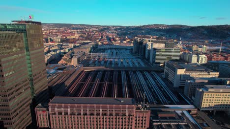 Aerial-drone-tilt-up-shot-over-Oslo-Central-train-station-near-Opera-Gate-in-Oslo,-Norway-during-evening-time