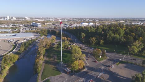 Eine-Drohne-Kreist-Um-Eine-Im-Wind-Wehende-Kanadische-Flagge-Neben-Dem-Stampede-Gelände-In-Calgary