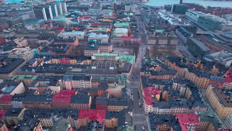 Stockholm-Aerial-drone-shot-flying-high-over-town-residential-buildings-alongside-streets-in-Sweden-during-evening-time-