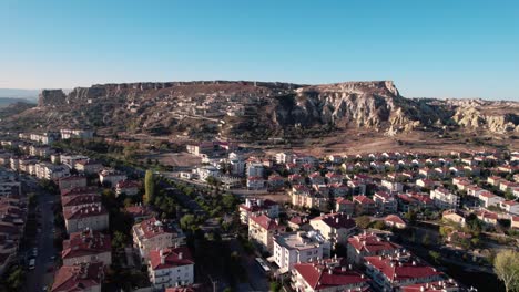 Aerial-drone-shot-over-Urgup-Town-houses-over-Temenni-Hill-in-Cappadocia-Region,-Turkey-during-morning-time