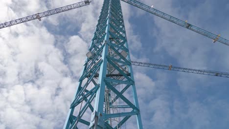 Construction-Crane-Metal-Column-with-Stairs-and-Blue-Cloudy-Sky-in-Background