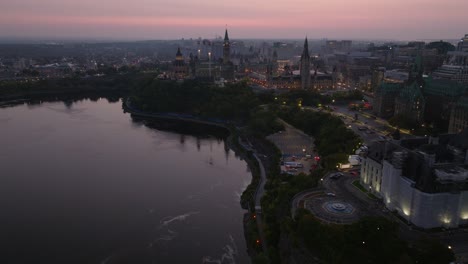 Drone-shot-at-sunrise-of-downtown-Ottawa,-showing-the-Ottawa-river,-the-supreme-court-and-the-Canadian-parliament