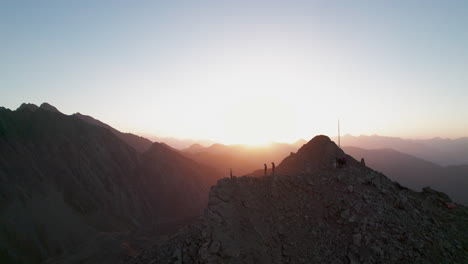 Tourists-Hiking-On-Summit-of-Mountain-at-Sunrise-in-Courmayeur-Region-in-Italian-alps,-Aerial-View