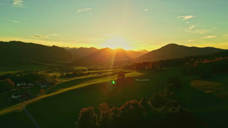 Aerial-view-of-a-beautiful-rural-town-and-fields,-colorful-fall-sunset-in-Austria