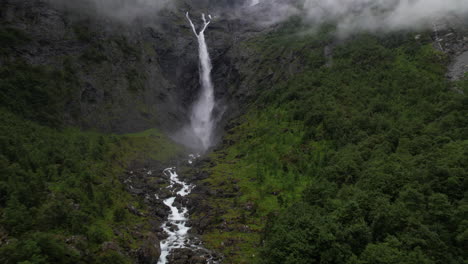 Aerial-View-of-Mardalsfossen-Waterfalls-in-Norway,-Water-Stream-Along-Mountain-Edge-in-Forest