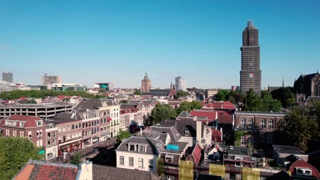 Aerial-drone-downward-movement-shot-over-the-historic-medieval-Dutch-city-centre-of-Utrecht-with-view-of-cathedral-in-distance-at-daytime