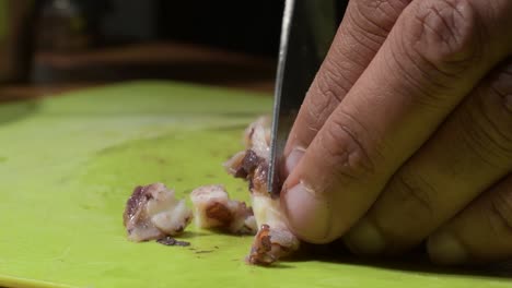 skilled-MAN-FISHERMAN-hands-cut-octopus-ON-GREEN-TABLE,-man-prepares-food-at-home
