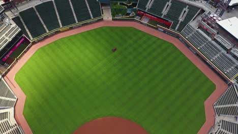 Aerial-top-down-shot-of-lawnmower-cutting-grass-inside-Truist-Park-Baseball-Stadium