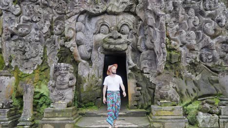 Journey-into-Mystery:-Male-Tourist-dressed-in-traditional-Balinese-Sarong-Explores-Goa-Gajah-Elephant-Cave,-one-of-the-holiest-temples-in-Ubud,-Bali