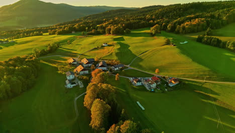 Aerial-shot-of-a-scenic-rural-landscape-with-a-small-village-at-sunset