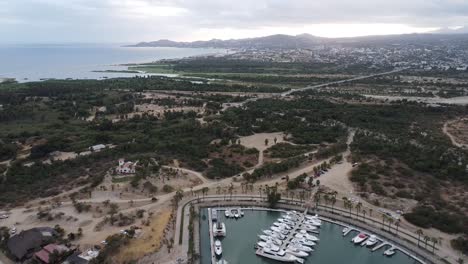 Luftaufnahme-über-Eine-Malerische-Küstenlandschaft-Mit-Blick-Auf-Den-Wunderschönen-Yachthafen-Von-Marina-Puerto-Los-Cabos-Mit-Geparkten-Booten-Am-Wasser-Während-Einer-Aufregenden-Reise-Durch-Mexiko