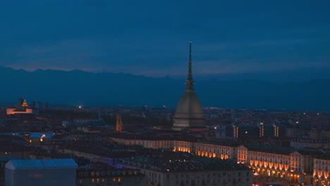 Nachtansicht-Der-Stadtlandschaft-Von-Turin-In-Italien-Mit-Dem-Mole-Antonelliana-Gebäude-Und-Den-Alpenbergen-Am-Horizont