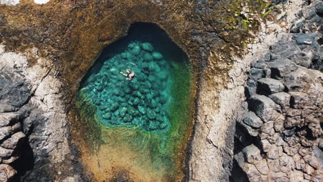 Swimming-and-floating-in-a-cove-with-turquoise-waters,-Fuerteventura