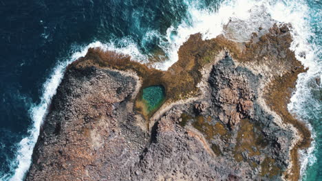 Aerial-of-a-private-cove-in-Caleta-de-Fuste,-surrounded-by-the-ocean