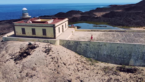 A-woman-walking-along-the-edge-of-a-monument-on-Los-Lobos-Island