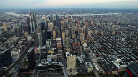 High-altitude-drone-shot-overlooking-the-metropolis-of-Philadelphia,-Fall-evening