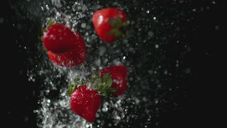 Strawberries-and-Water-Spray-in-Front-of-Black-Background