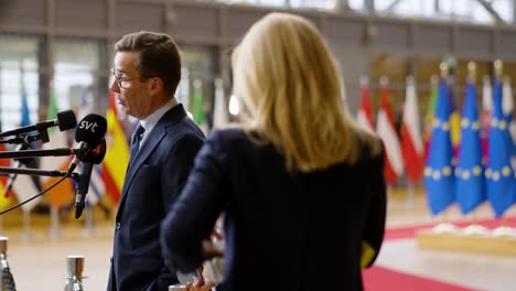 Swedish-Prime-Minister-Ulf-Kristersson-talking-to-the-press-at-the-European-Council-summit-in-Brussels,-Belgium---Medium-profile-shot