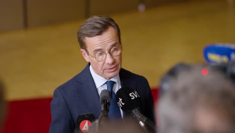 Swedish-Prime-Minister-Ulf-Kristersson-talking-to-the-press-at-the-European-Council-summit-in-Brussels,-Belgium---Medium-shot