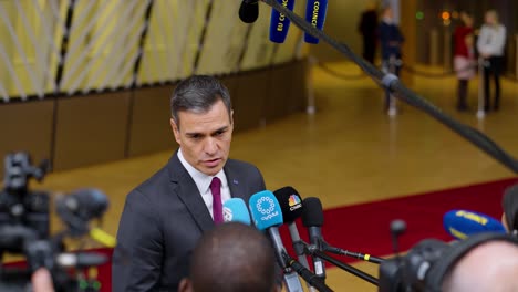 El-Primer-Ministro-Español,-Pedro-Sánchez,-Hablando-Con-Un-Periodista-De-Piel-Oscura-En-La-Cumbre-Del-Consejo-Europeo-En-Bruselas,-Bélgica---Plano-Medio.