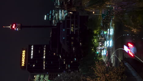 Sydney-Tower-Und-Stadtverkehr-In-Einem-Vertikalen-Nächtlichen-Zeitraffer-über-Dem-Cross-City-Tunneleingang