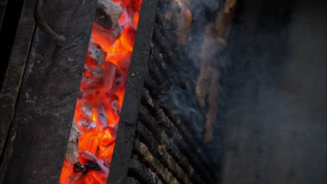 Slow-motion-of-meat-beef-steaks-cooked-on-a-grill-with-red-hot-burning-charcoal-wood-in-a-restaurant